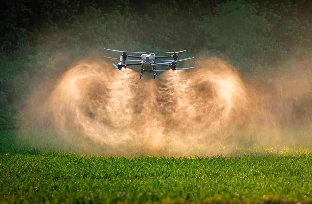 Agricultural drone spraying crops in field