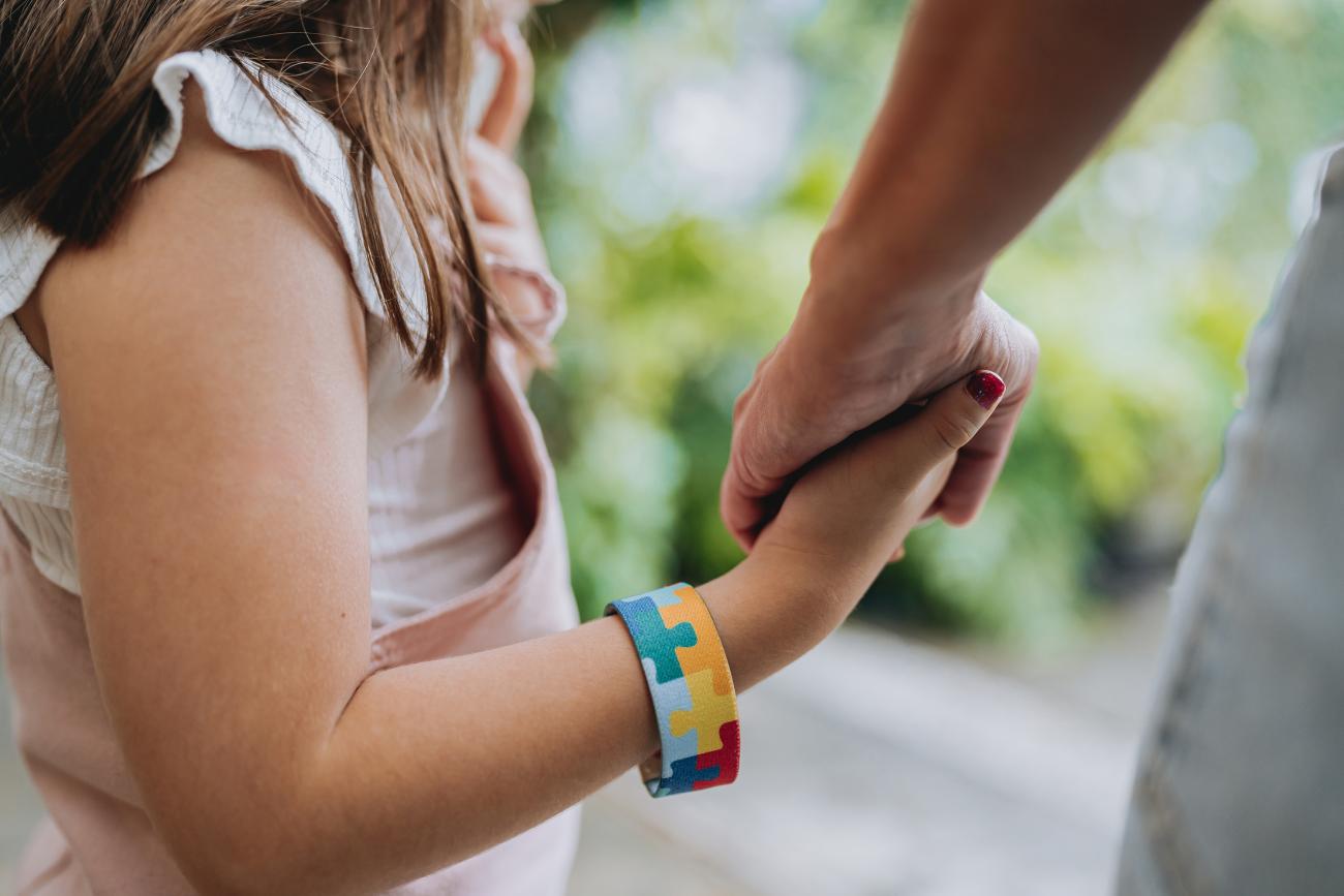 Johns Hopkins research team image of parent-child holding hands, symbolizing the gene-environment interaction of autism risk factors