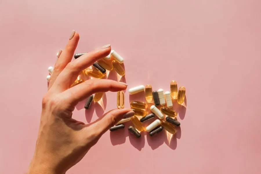 A woman taking a supplement, representing the rise of personalized biomarker-driven supplementation