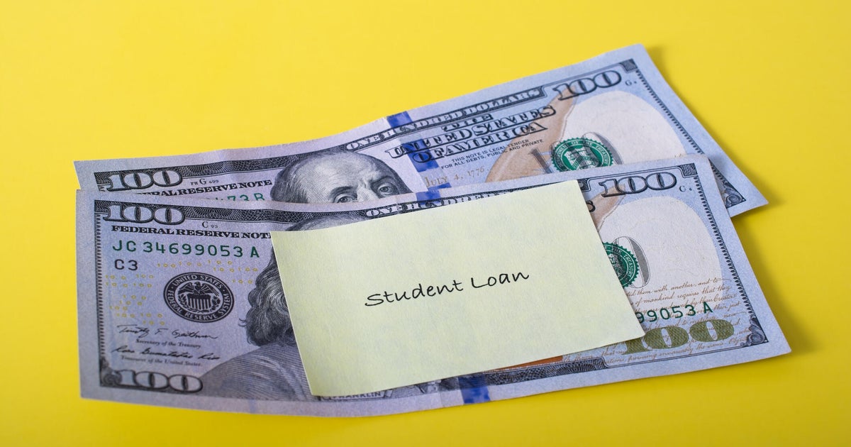 Student filling out financial documents at a desk