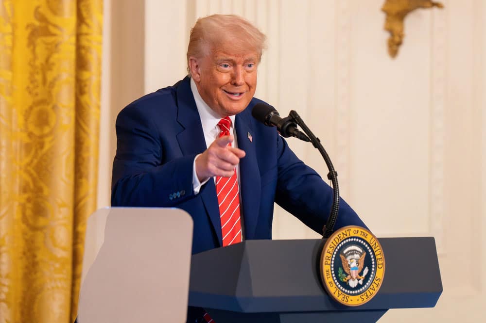 Former President Trump at a podium, representing the US trade tariff policy discussion