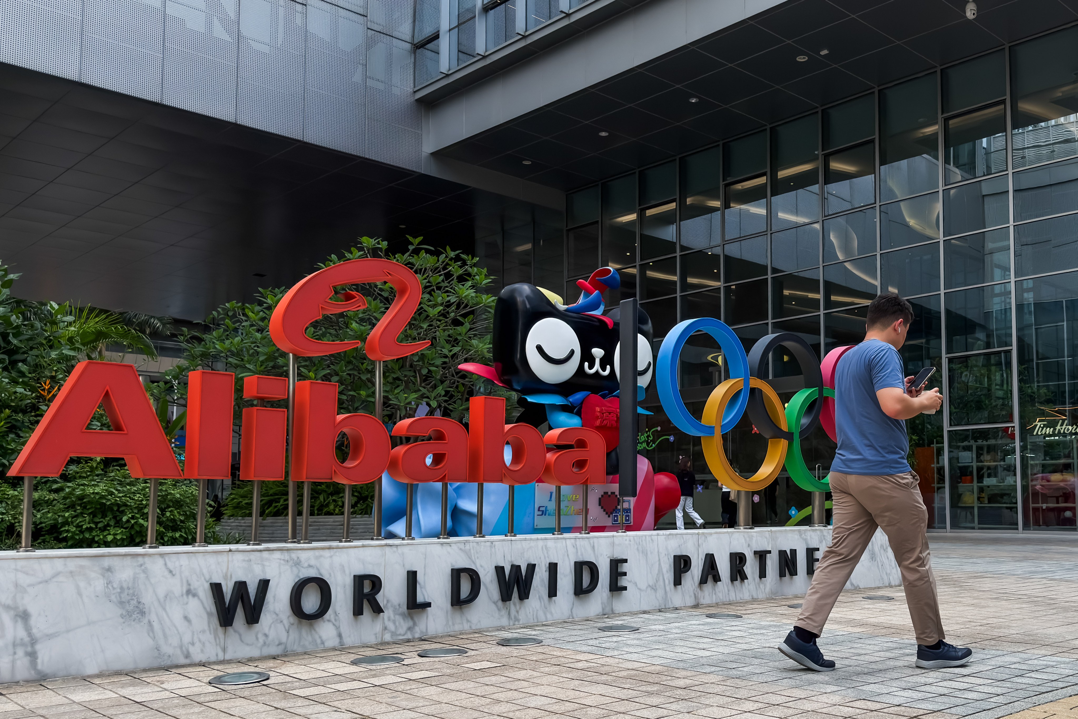 Pedestrian walks past Alibaba office in Shenzhen
