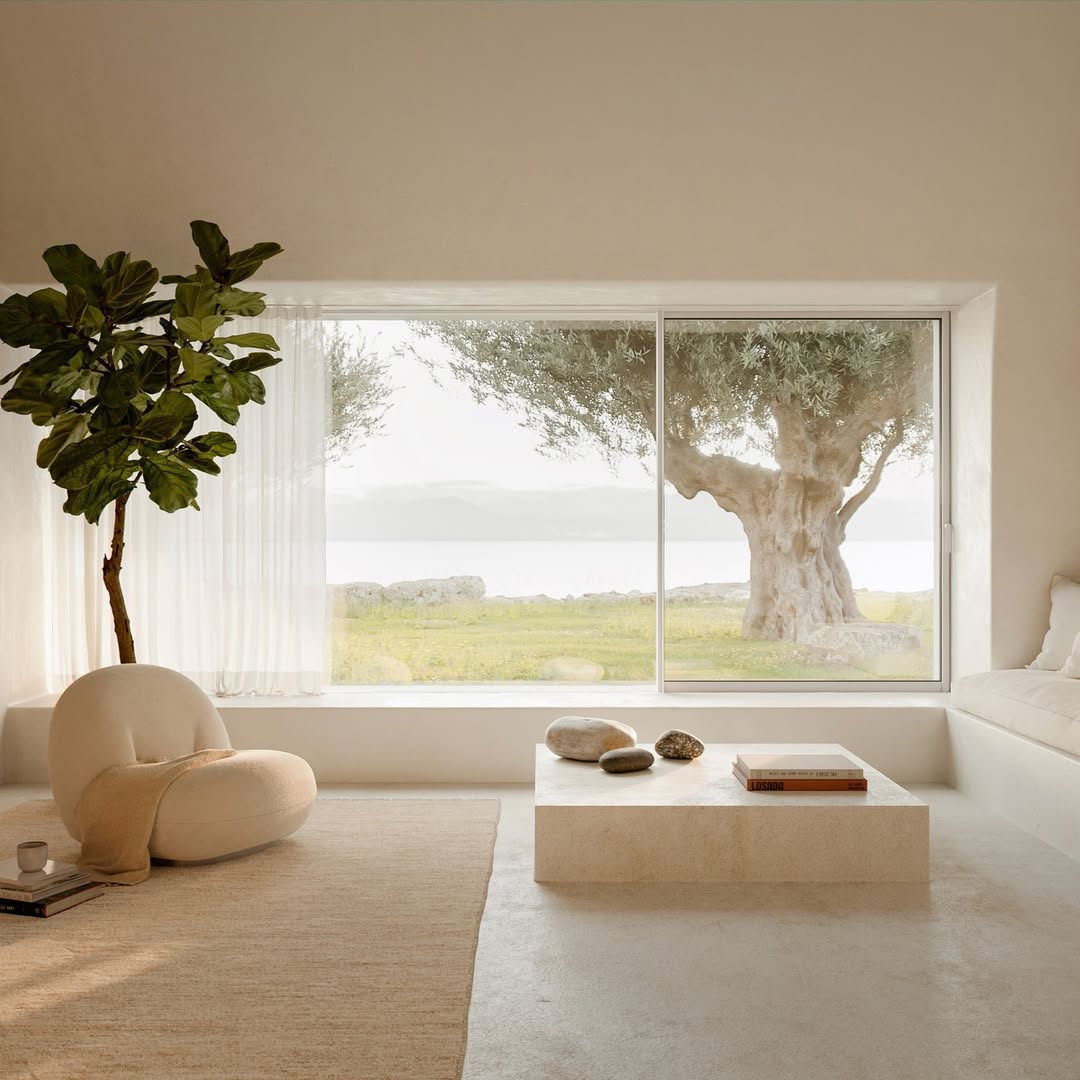 Minimal living space with large windows framing a nature view