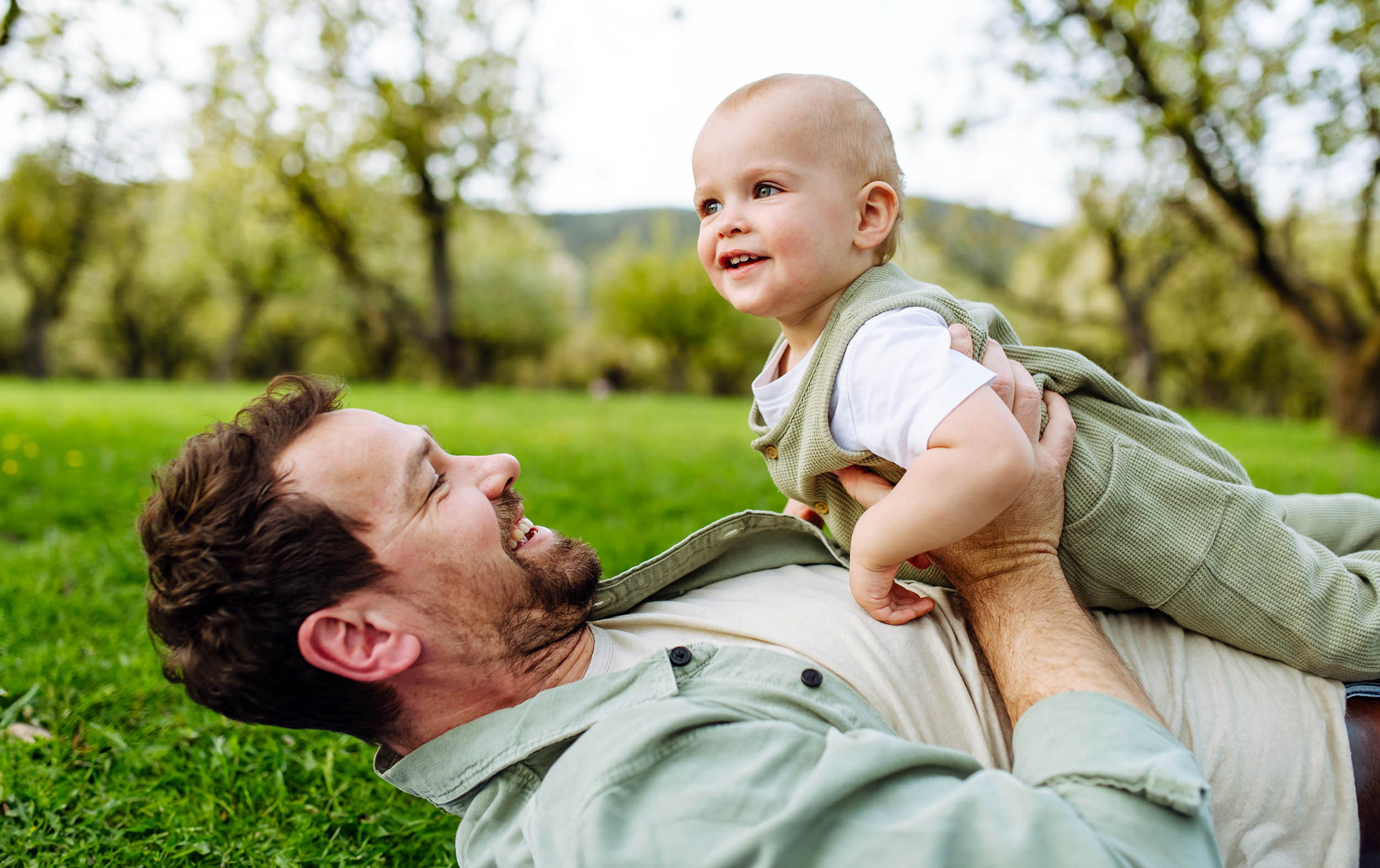 A father engaging with a baby, illustrating the health benefits of early paternal involvement