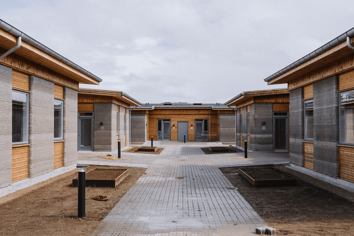 The Skovsporet 3D-printed student apartments arranged around a shared courtyard in Holstebro, Denmark