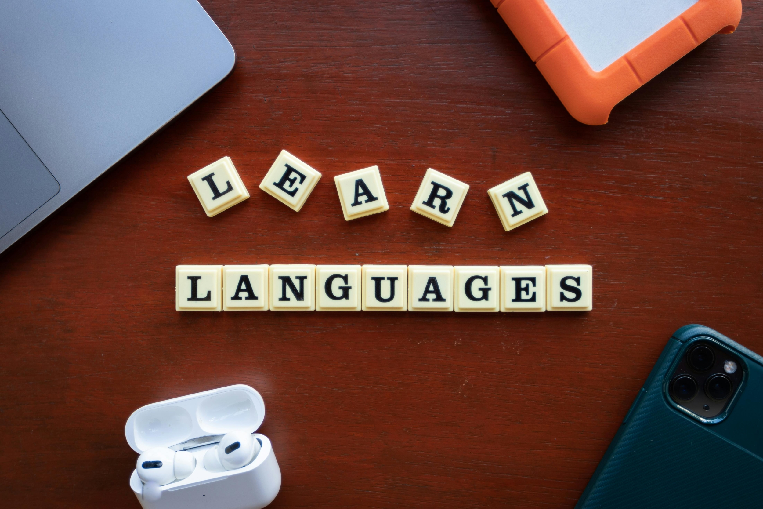 Colorful language-learning dice spelling out "learn languages" on a desk