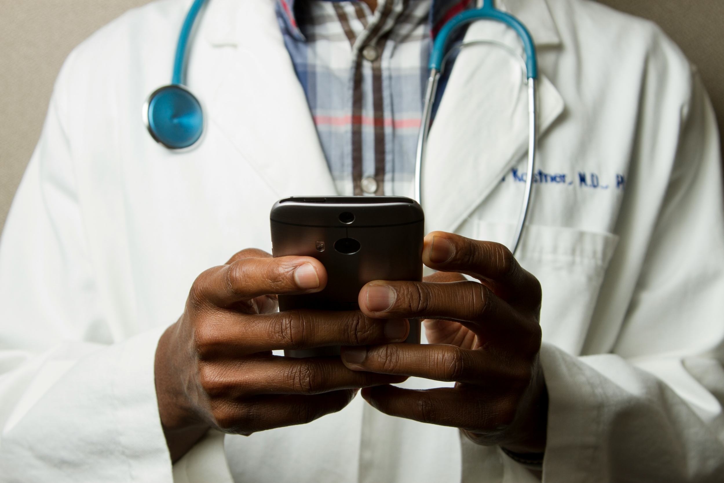Doctor using smartphone AI diagnostic tool in clinical setting