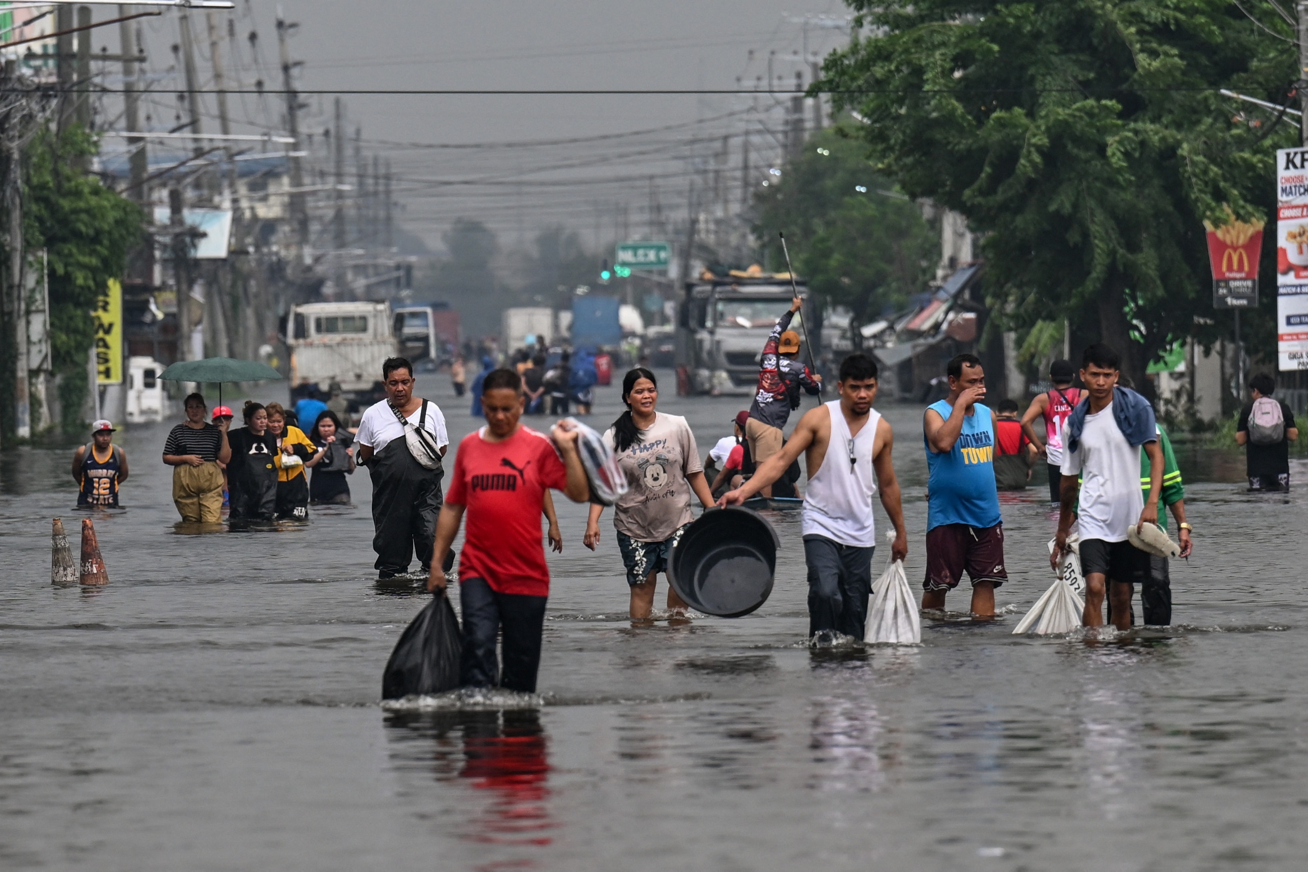 People wading through flooded street during heavy rains
