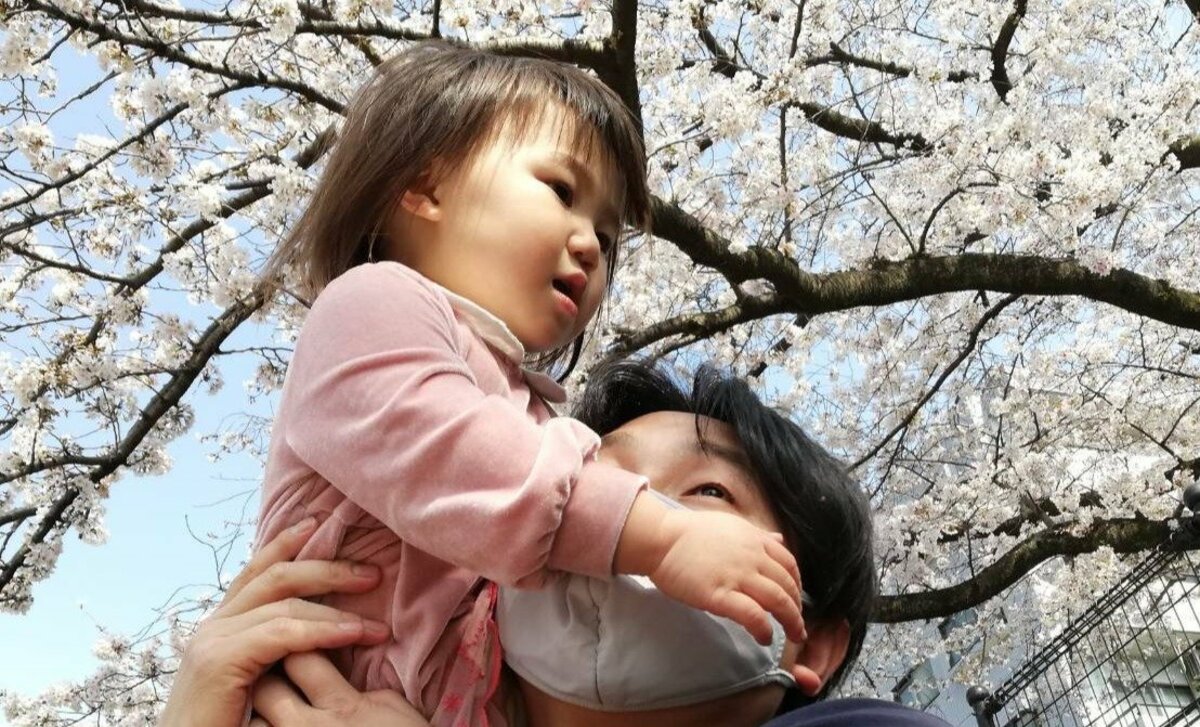 Photo of a father holding a baby, illustrating the rise in male childcare leave