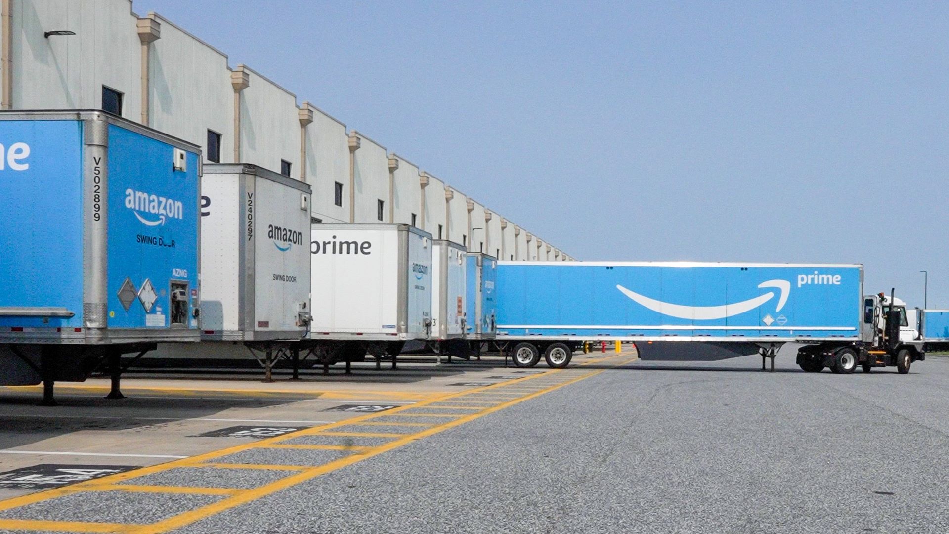 Blue Amazon Prime trailers parked at an Amazon warehouse fulfillment center