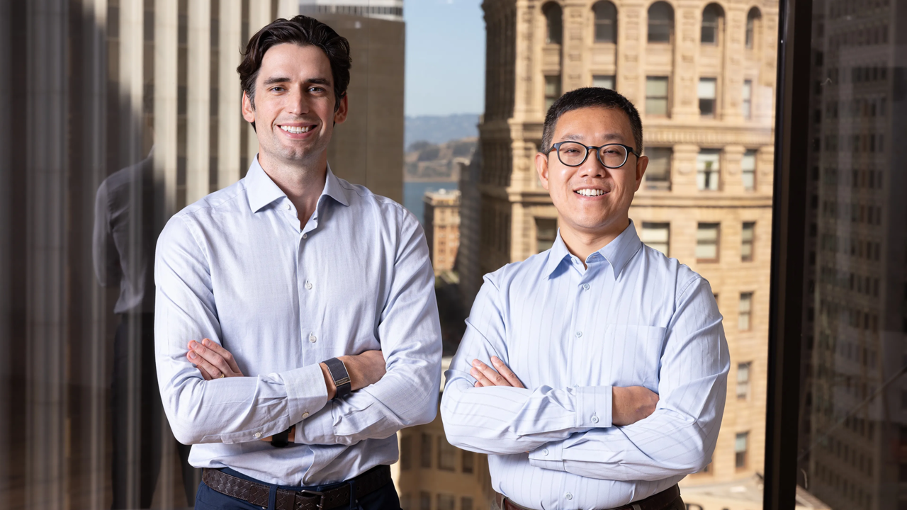 Loop co-founders Matt McKinney and Shaosu Liu standing in front of a San Francisco skyline window