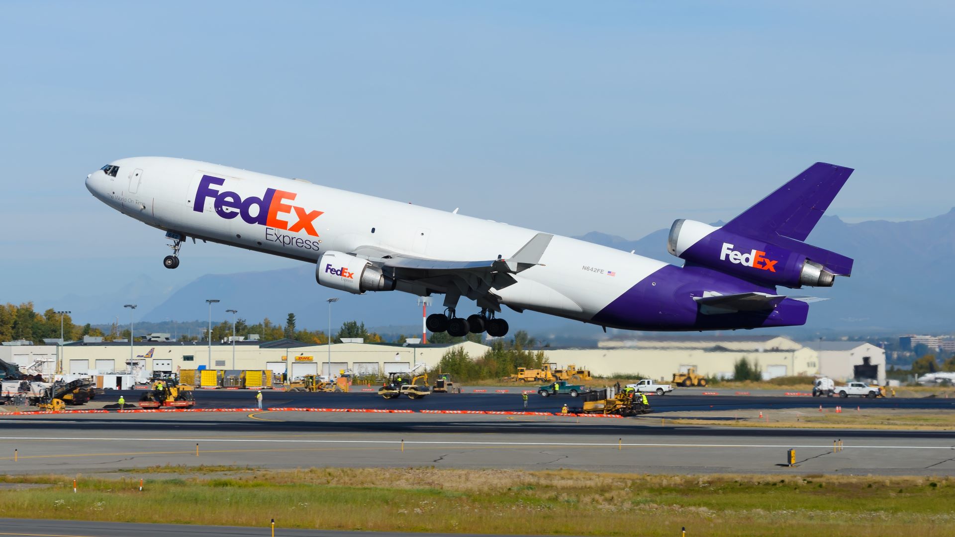 A purple-tailed FedEx MD-11 freighter aircraft taking off