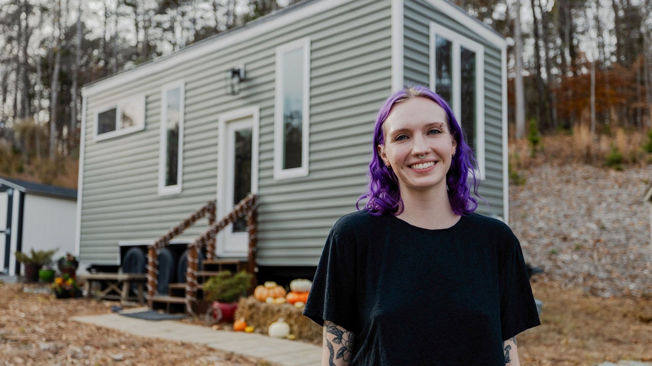 Young couple standing in front of their tiny home