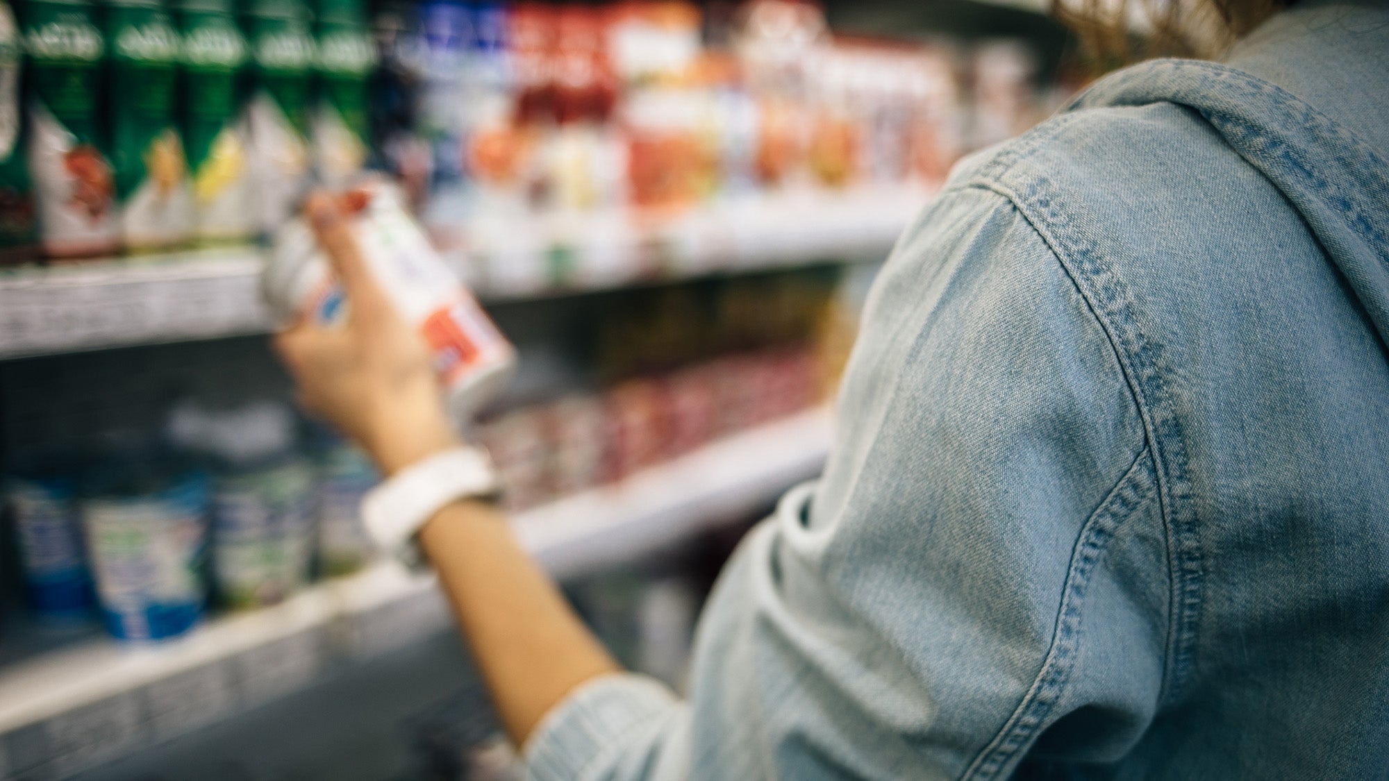Woman reading nutrition label at grocery store