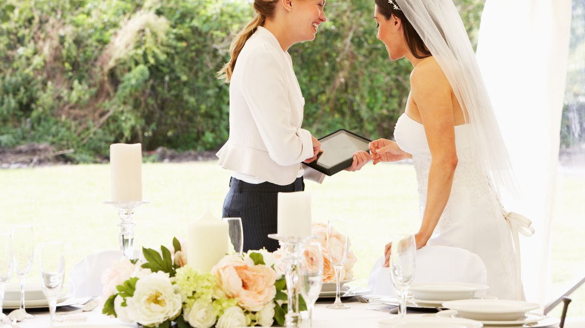 Wedding planner consulting with a bride in a marquee