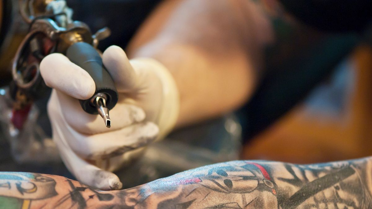 Tattoo artist at work illustrating 2027 trend predictions