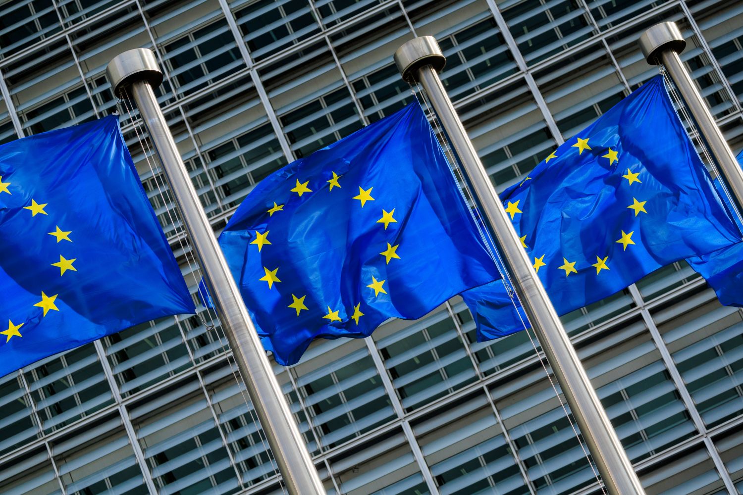 EU flags at an angle, representing the EU Council's announcement on AI Act amendments