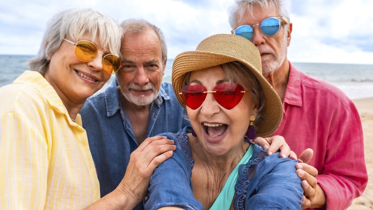 Happy seniors celebrating active retirement on a beach