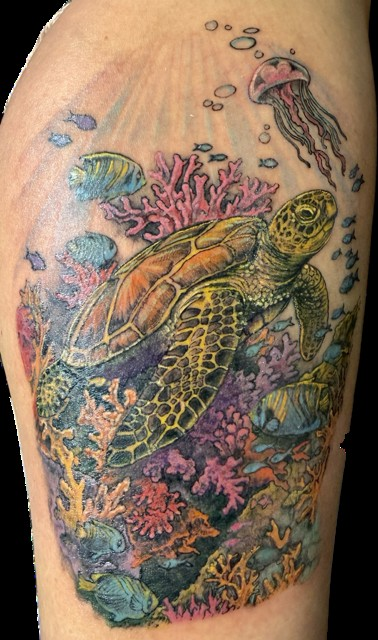 Tattoo artist working on a client's leg at Ink Couture Tattoos