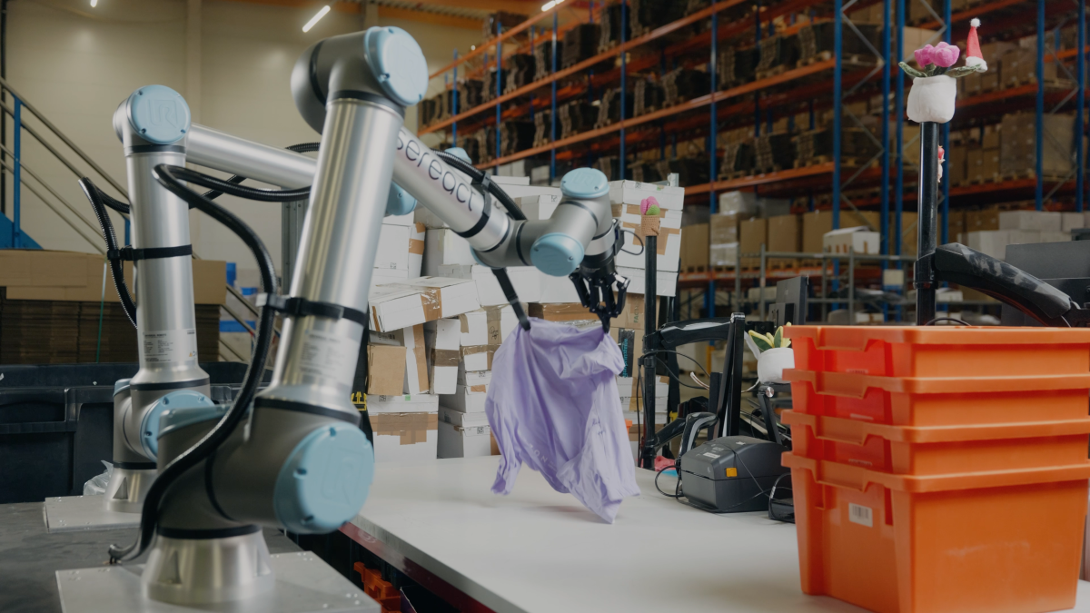 Robotic arm handling packages in a warehouse