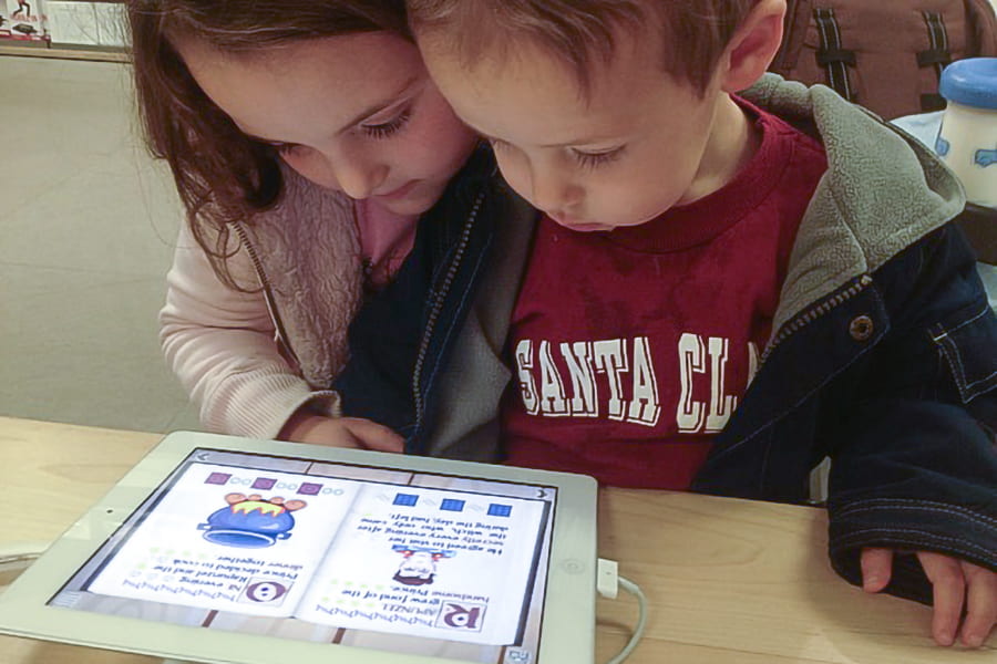 Young children using a tablet, illustrating the link between device-based soothing and behavioral outcomes