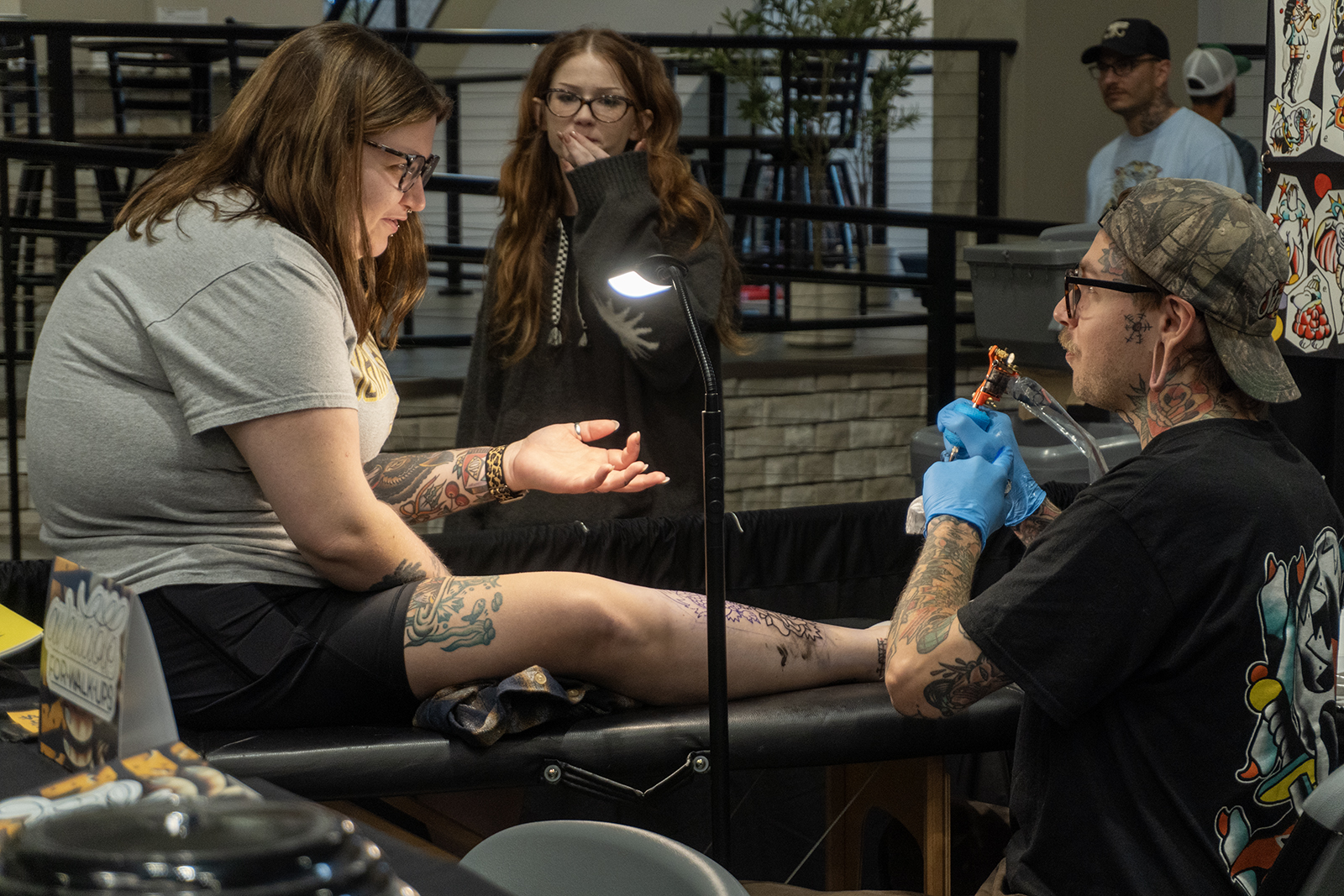 Tattoo artist inking a design at the Bizarre Bazaar Tattoo Convention