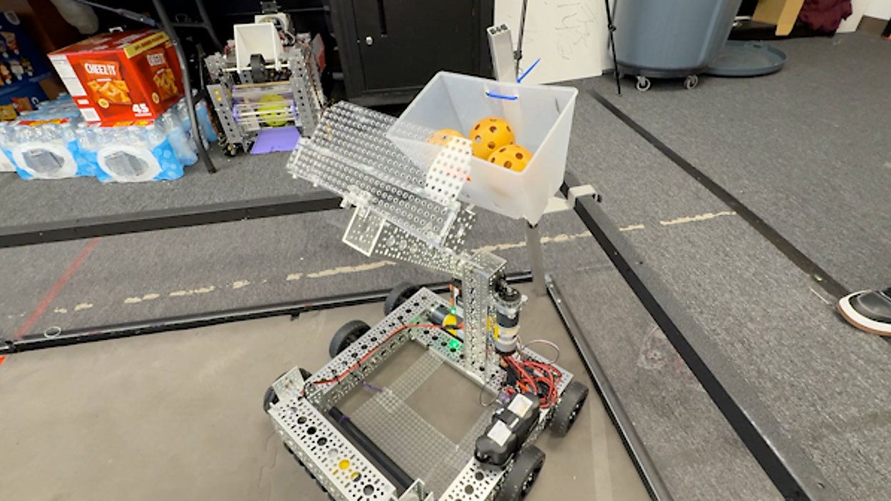 Students building and testing robots in a summer camp setting