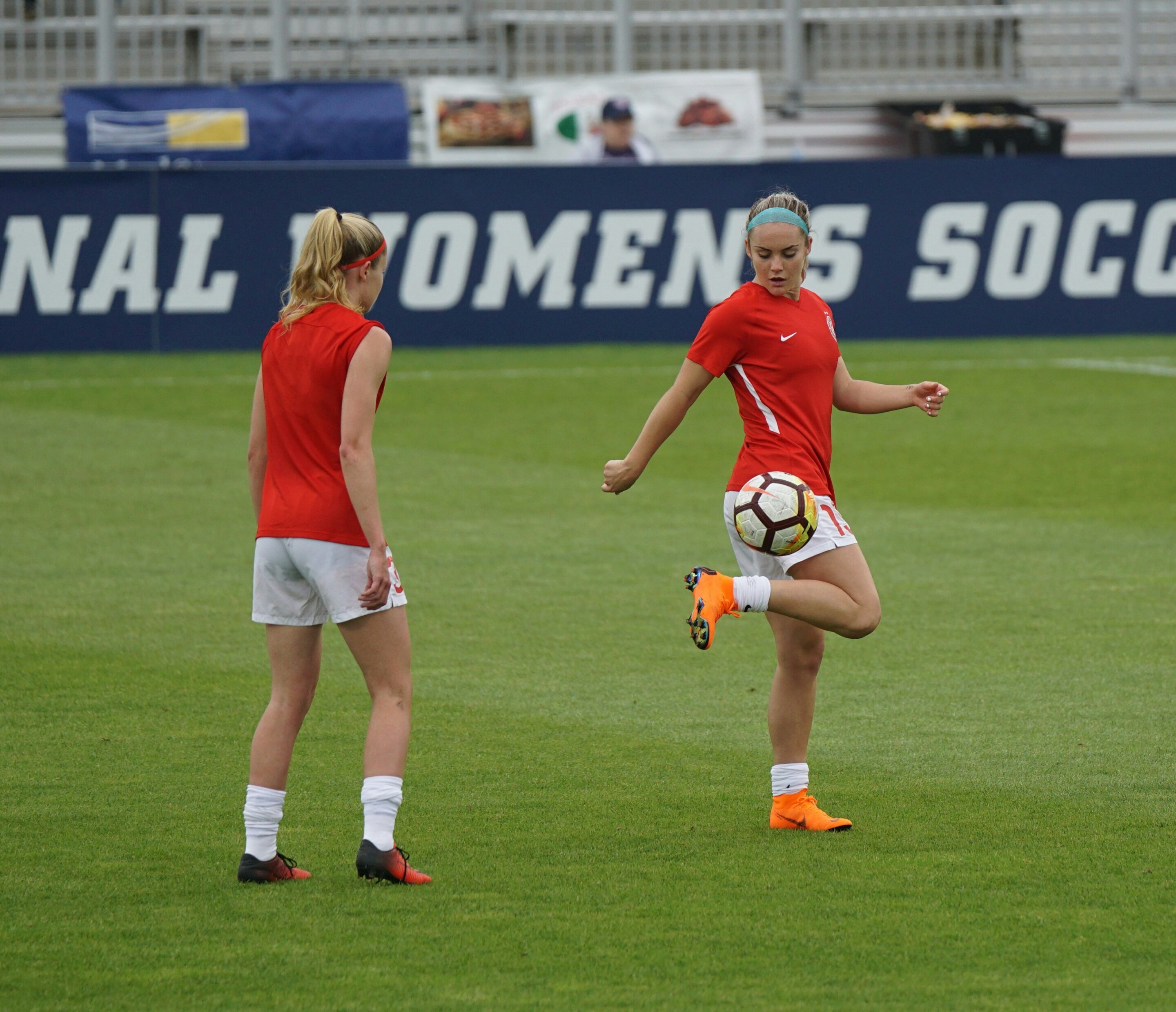 Girls playing football on a green pitch during training, illustrating ACL prevention research