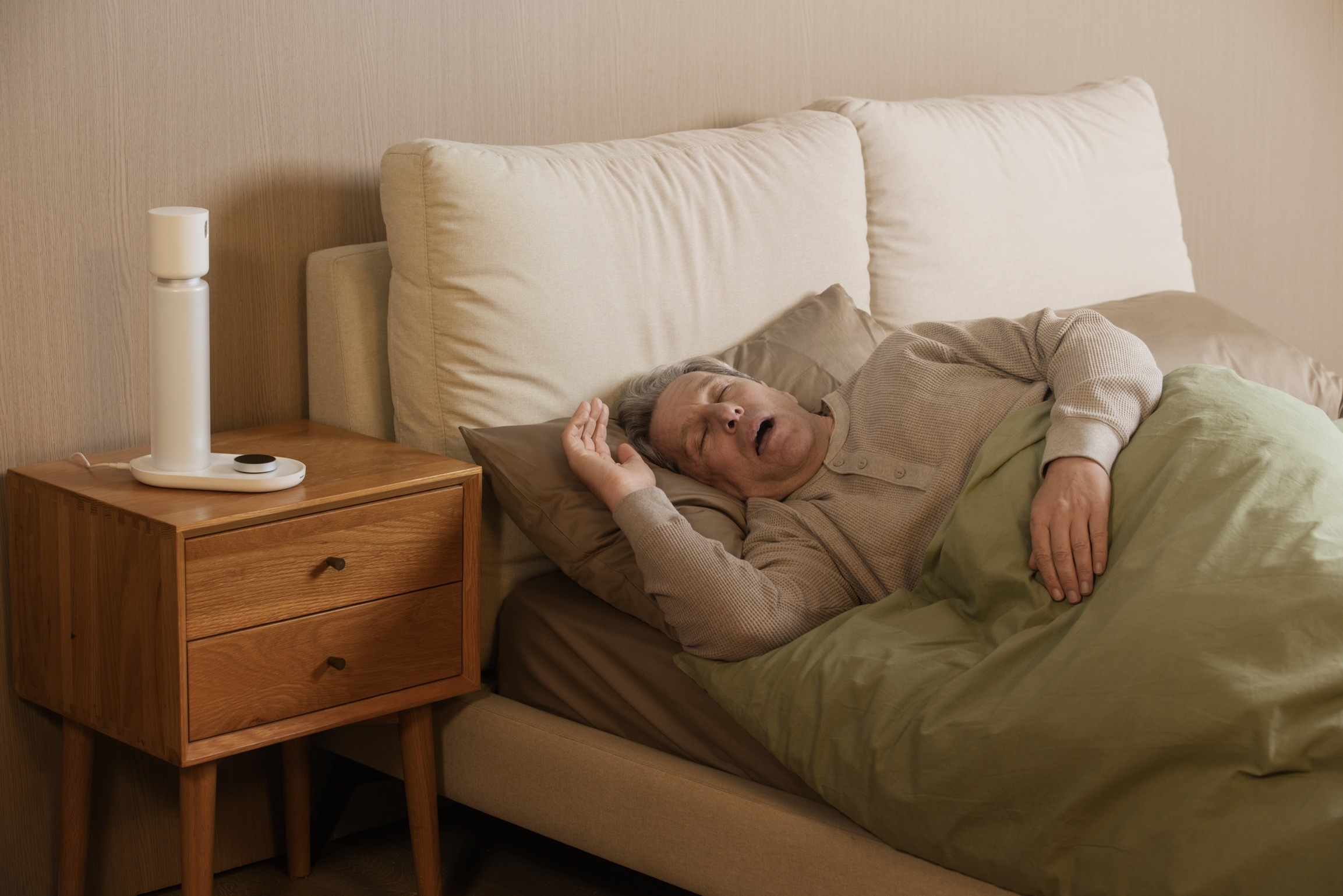 An elderly person using the Sleepal AI Lamp for contactless sleep monitoring