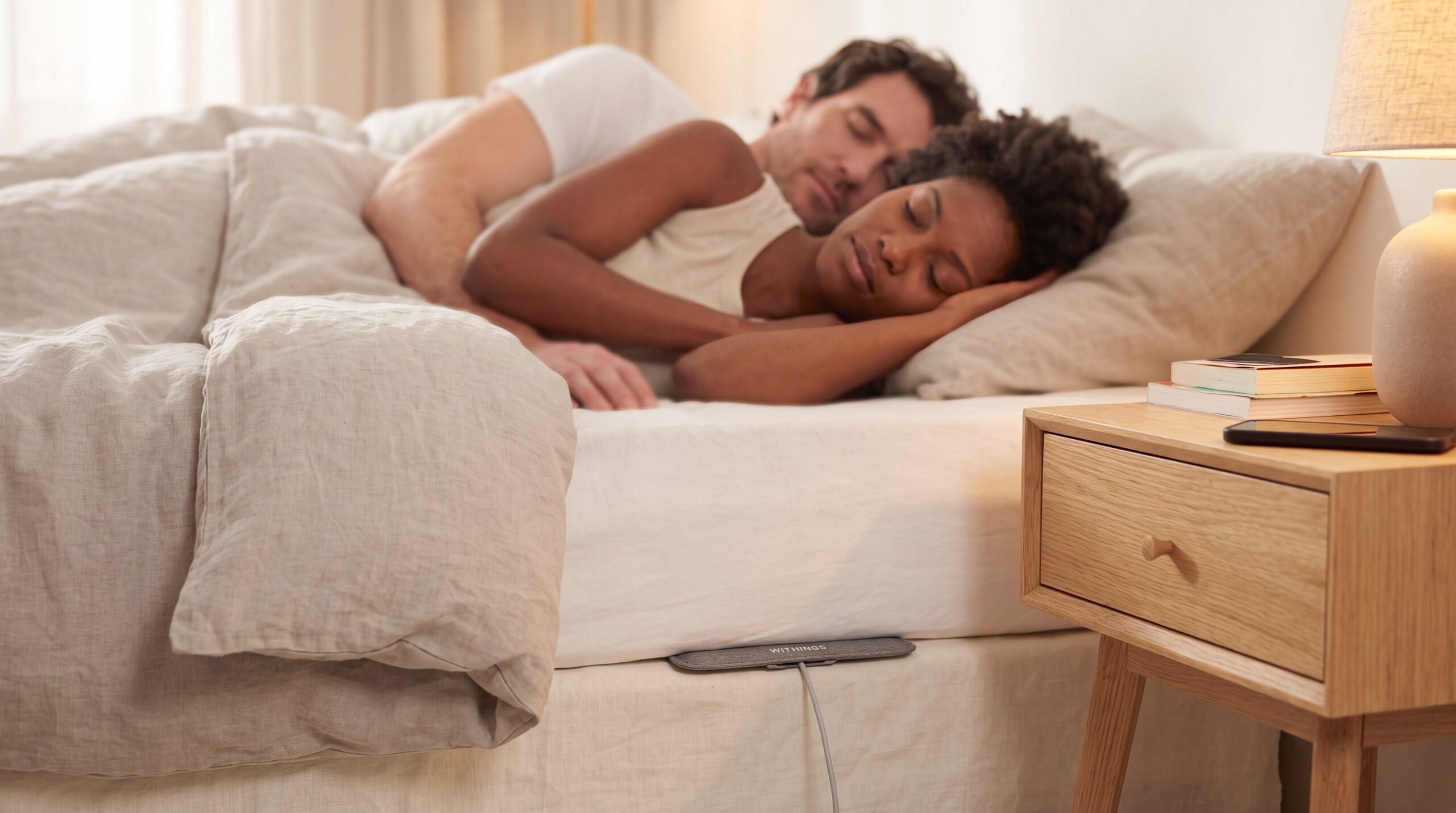 Couple sleeping on a mattress with sleep tracking technology