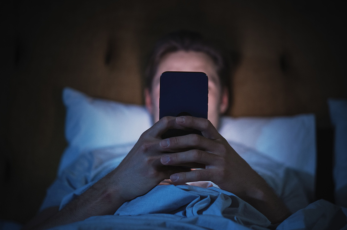 Student scrolling on smartphone — digital therapy app shown to ease depression, anxiety, and eating disorder symptoms