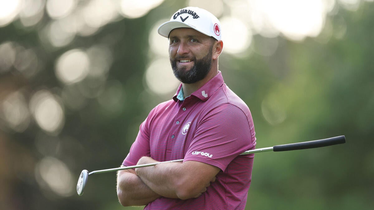Jon Rahm smiling in a pink golf shirt, highlighting his separation from LIV Golf