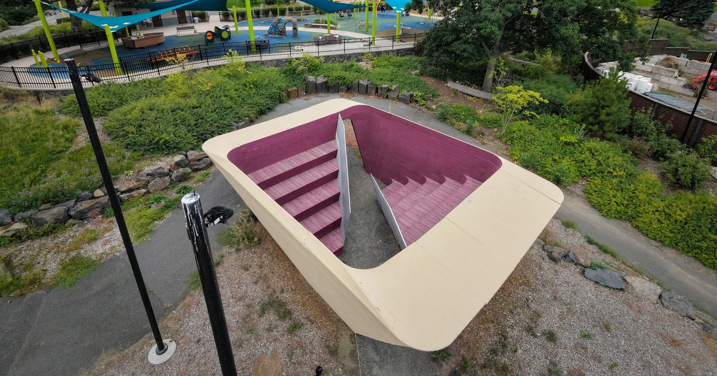 The Stepwell art installation at Riverfront Park in Spokane, appearing weathered and secured behind barriers.