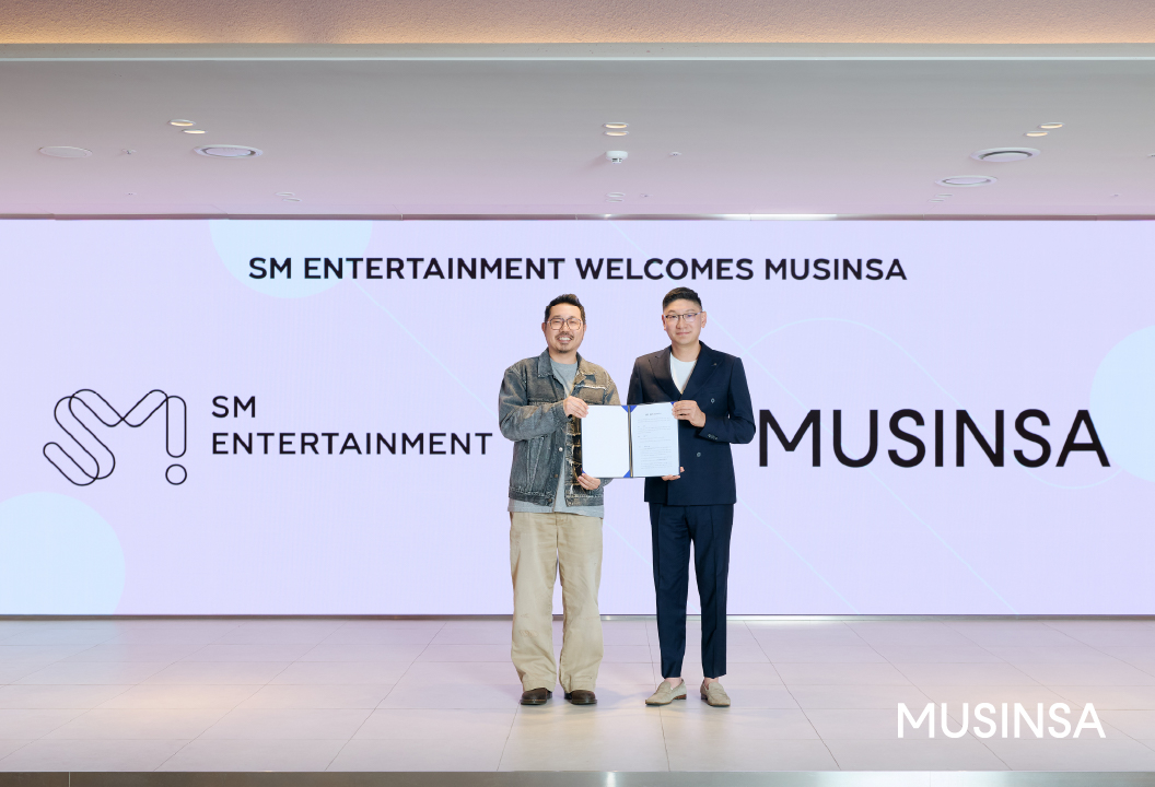 SM Entertainment and Musinsa executives signing the MOU