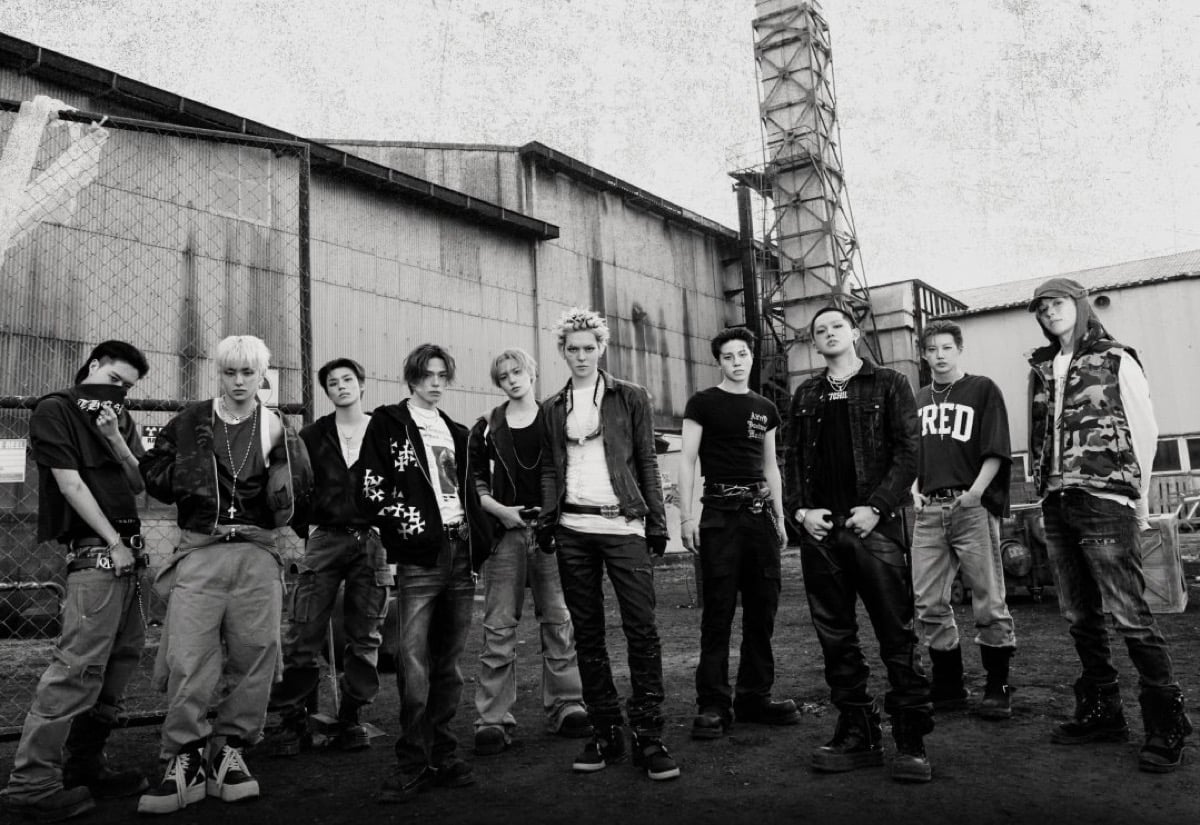 TREASURE members posing with NEW WAV album artwork