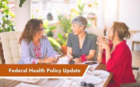 Three women sitting at a table in discussion, representing the bipartisan focus on menopause health policy