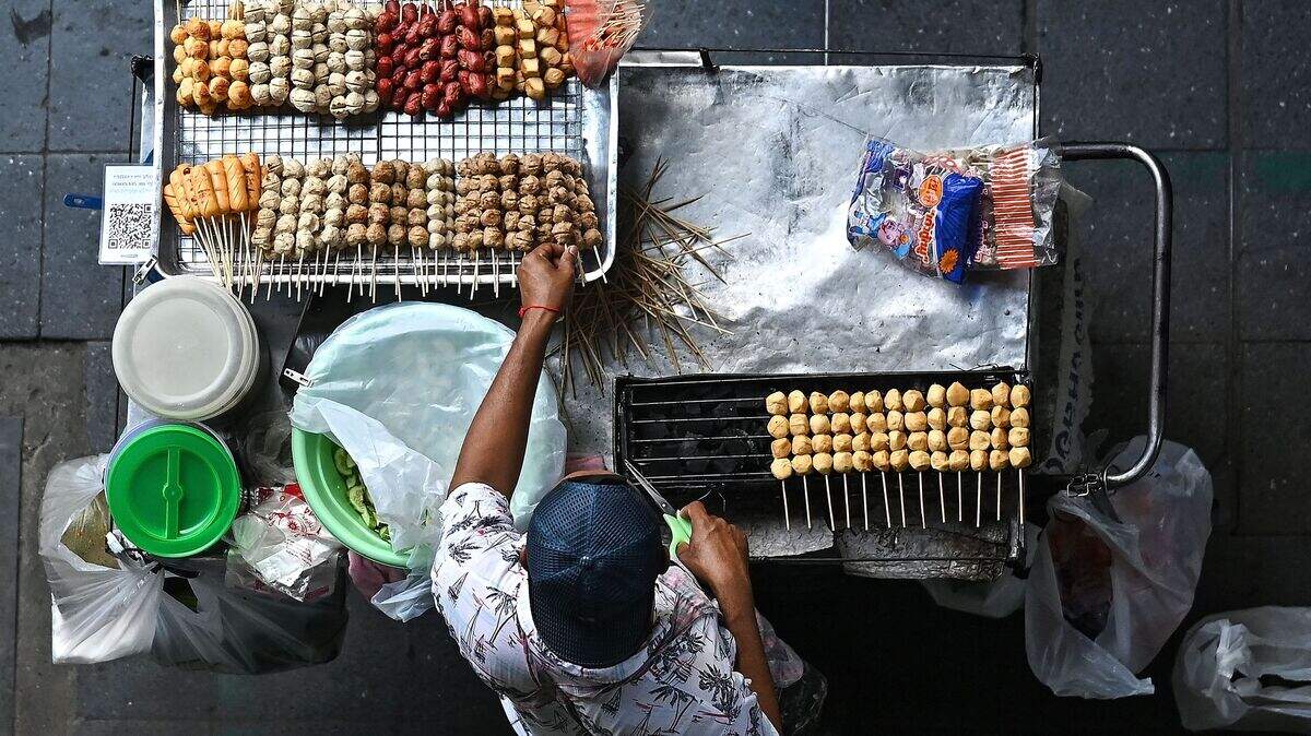 Street food stall in Southeast Asia serving traditional noodle dishes