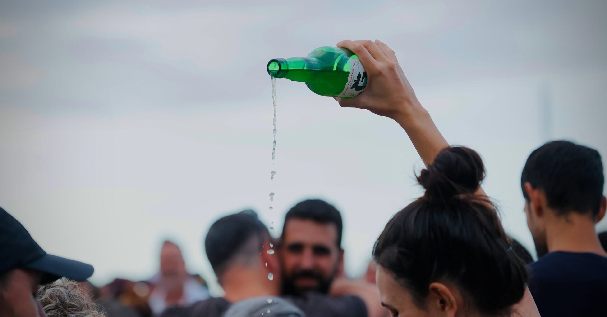 A trained cider pourer demonstrates the traditional escanciado technique at an Asturian festival