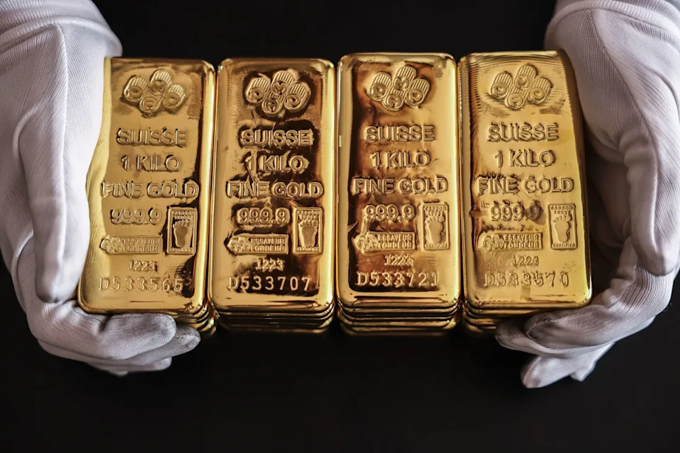 Image showing gold bars held by gloved hands, representing central bank storage