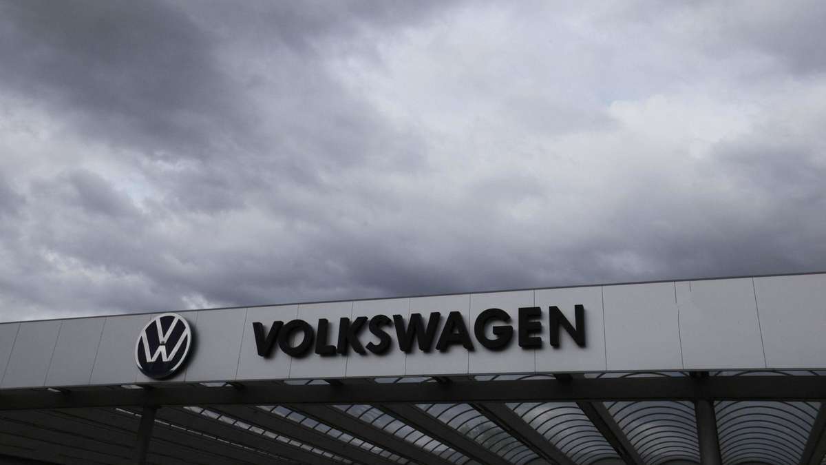 Dark clouds over Volkswagen factory gates symbolizing industry crisis