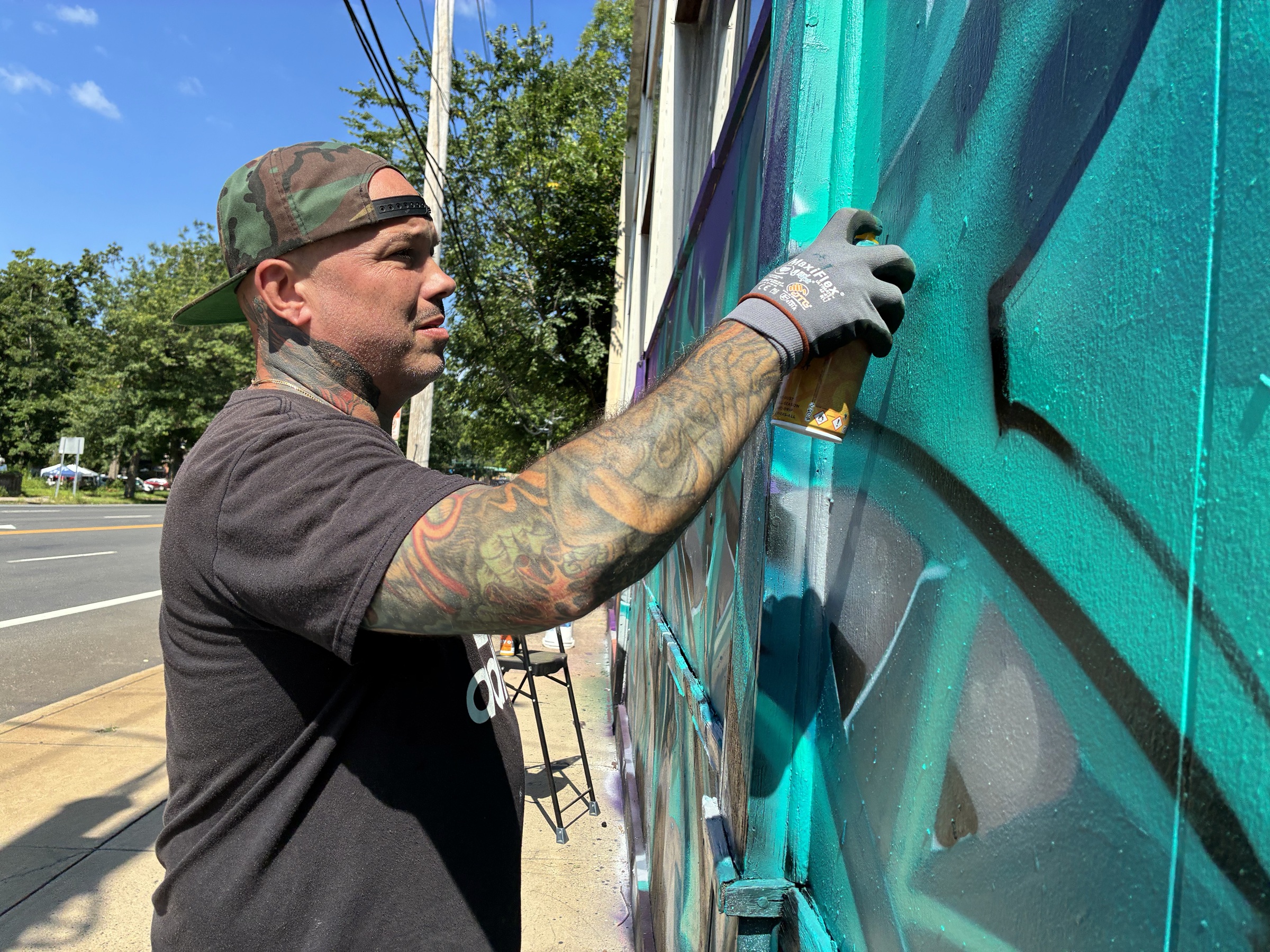Graffiti artists painting a new mural on an abandoned building wall