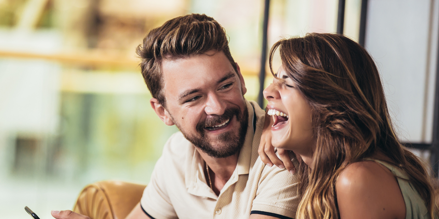 Happy couple laughing, illustrating research on relationship satisfaction