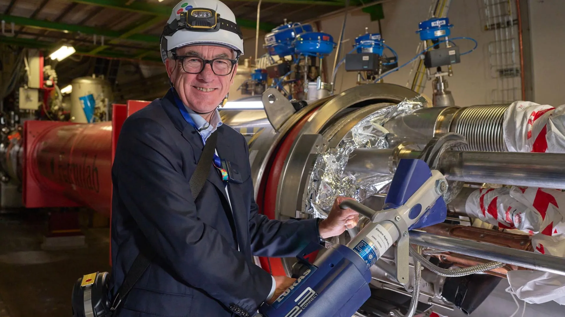 CERN Director-General Mark Thomson stands near LHC magnets being disconnected