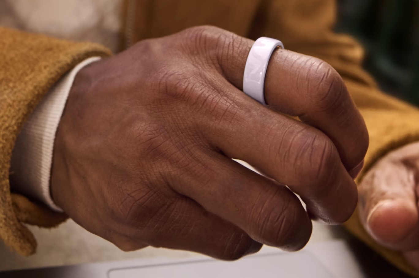 The Oura Ring 4 in ceramic finish, resting on a surface