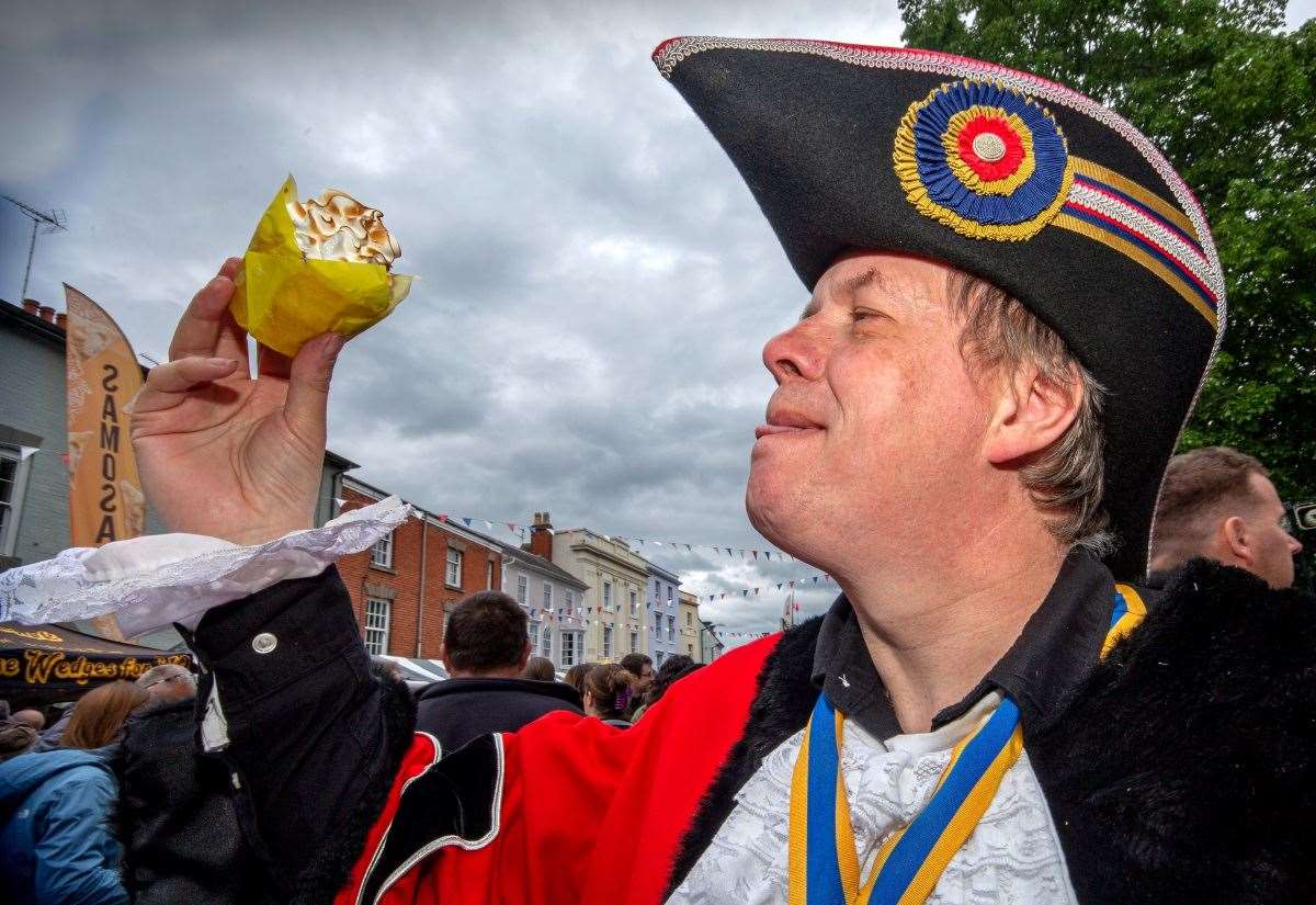 Visitors sampling pastries and hot food at Alcester Food Festival 2026, stalls lining the historic market street
