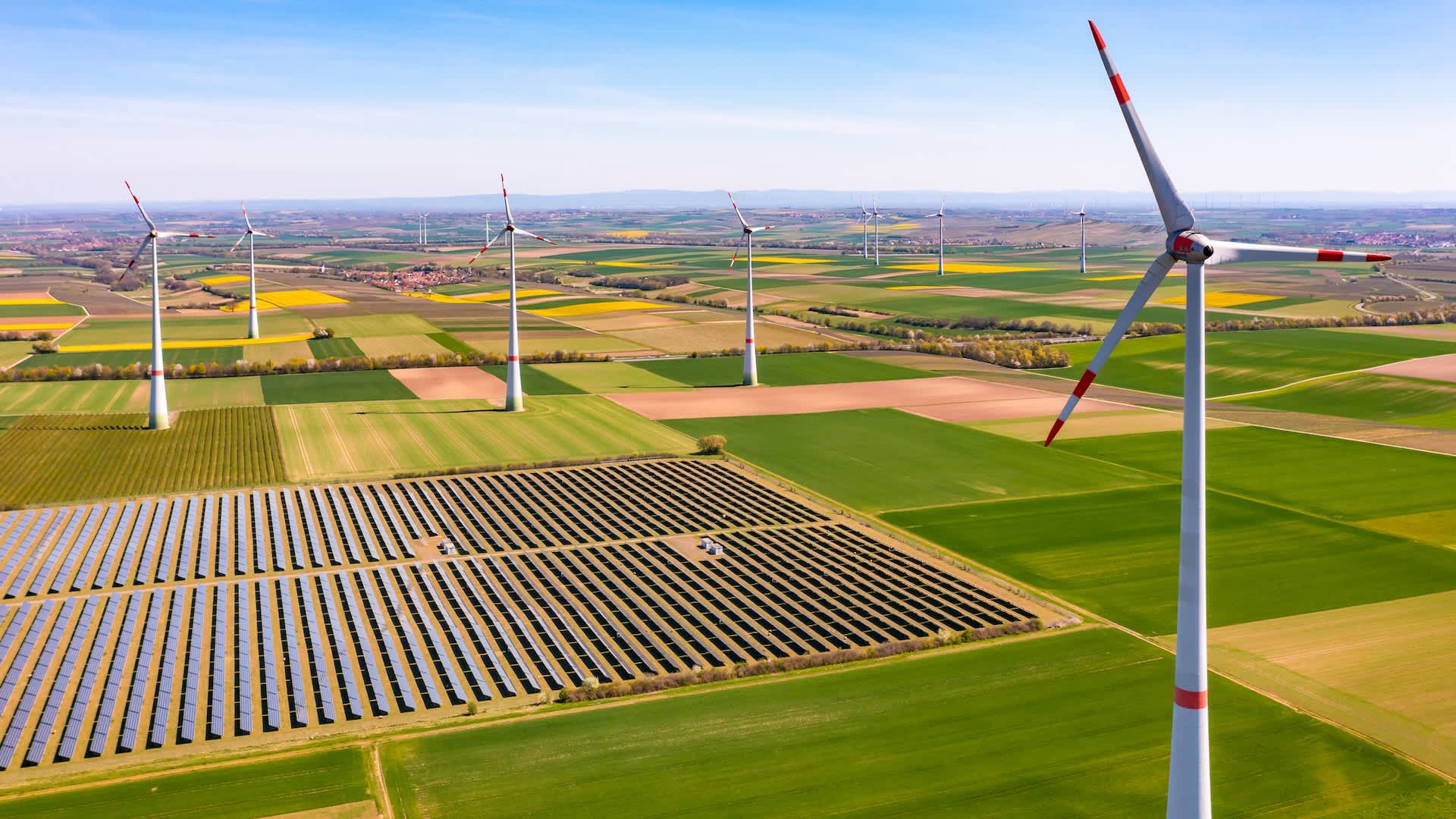 Wind turbines and solar panels generating clean power in the European countryside