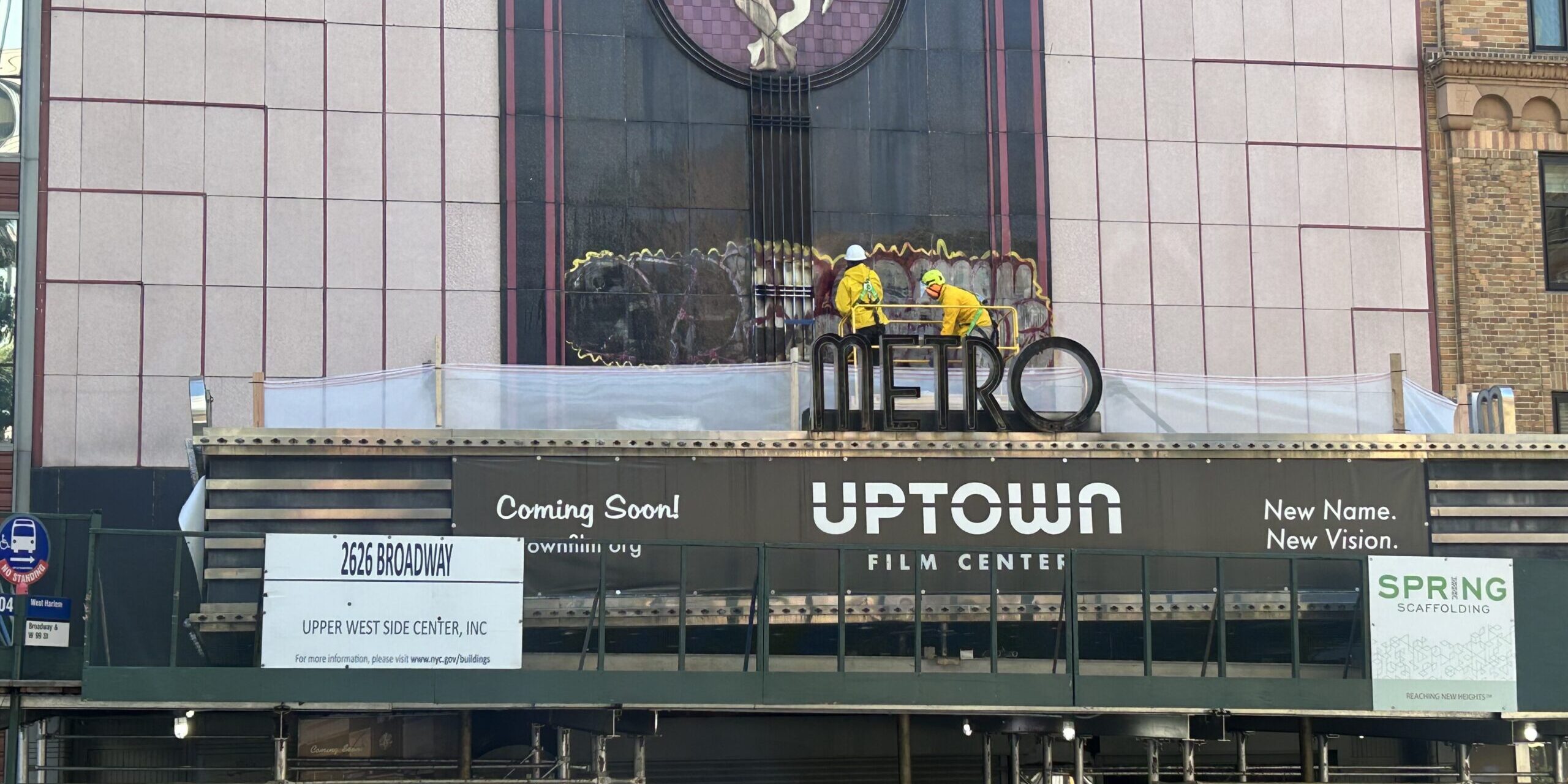 Construction workers removing graffiti from the Metro Theater