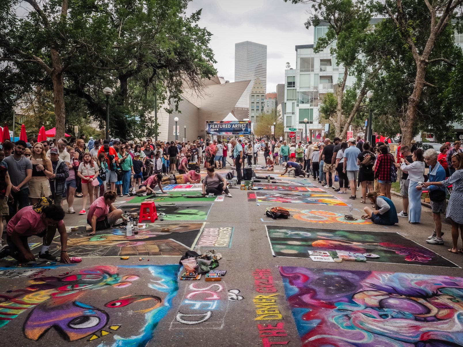 Denver Chalk Art Festival participants creating street art on pavement