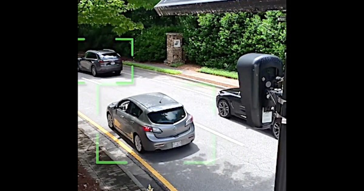 Flock AI surveillance cameras tracking cars on a traffic road